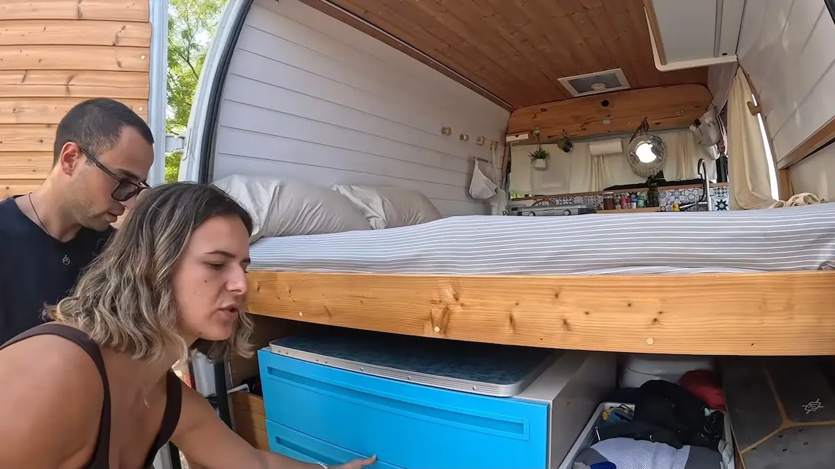 Sara y Tony muestran el cajón de almacenamiento bajo la estructura de la cama en su camper