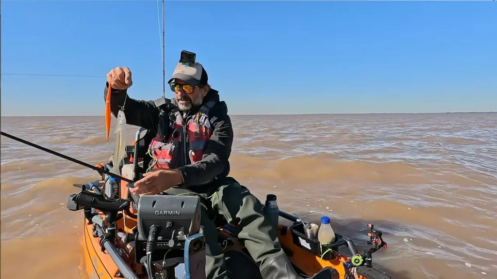 Rodrigo Cobas mostrando el primer pejerrey de la temporada en kayak por el Río de la Plata