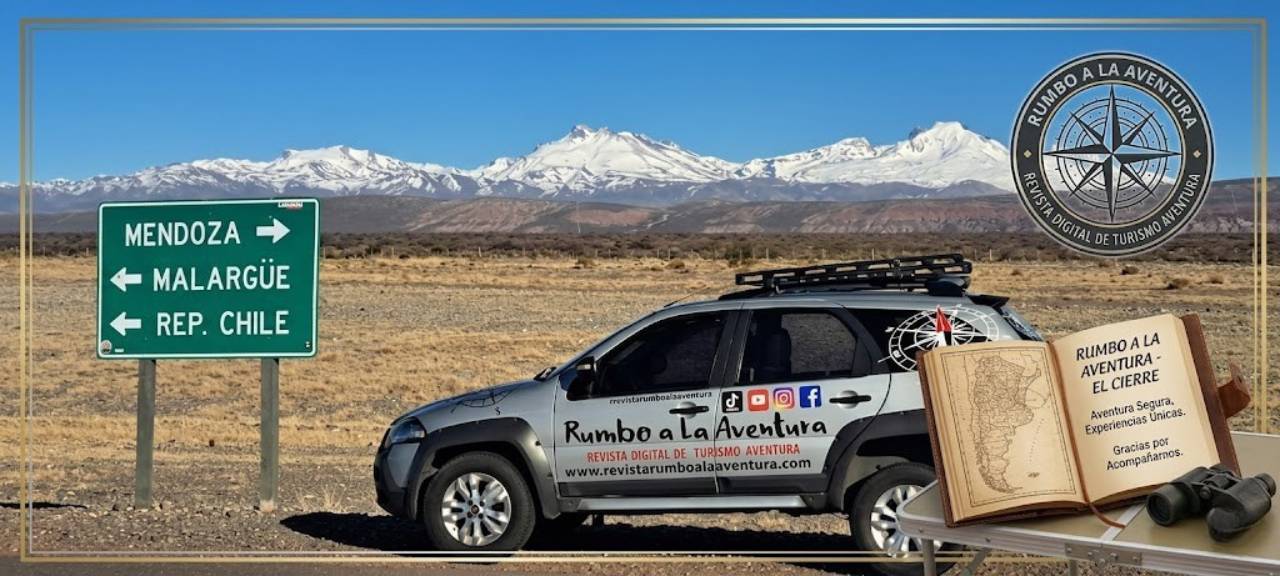 Camioneta Fiat Palio Adventure de la revista al lado de cartel de Mendoza y Malargue con montañas nevadas.