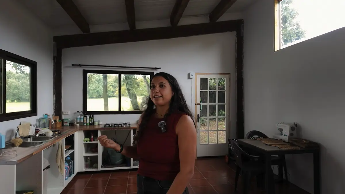 Cocina rústica con ventanales hacia las colinas y el campo en la finca autosuficiente de Estrella.