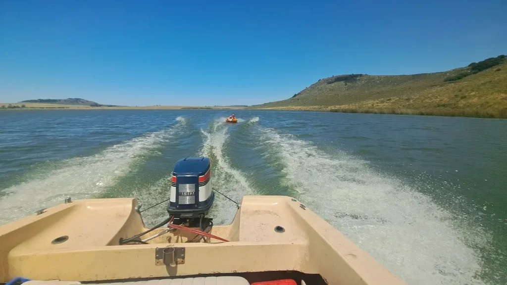Lancha a motor remolcando un gomón de arrastre o tubing en Laguna La Brava frente al Club de Pesca Balcarce