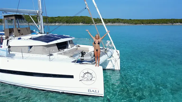 Catamarán fondeado en aguas cristalinas y turquesas de Bahamas durante una travesía náutica.
