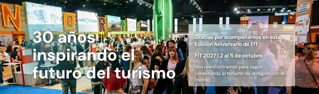 Pabellón de exposiciones de FIT 2026 con cartel de 30 años inspirando el futuro del turismo y anuncio de FIT 2027.