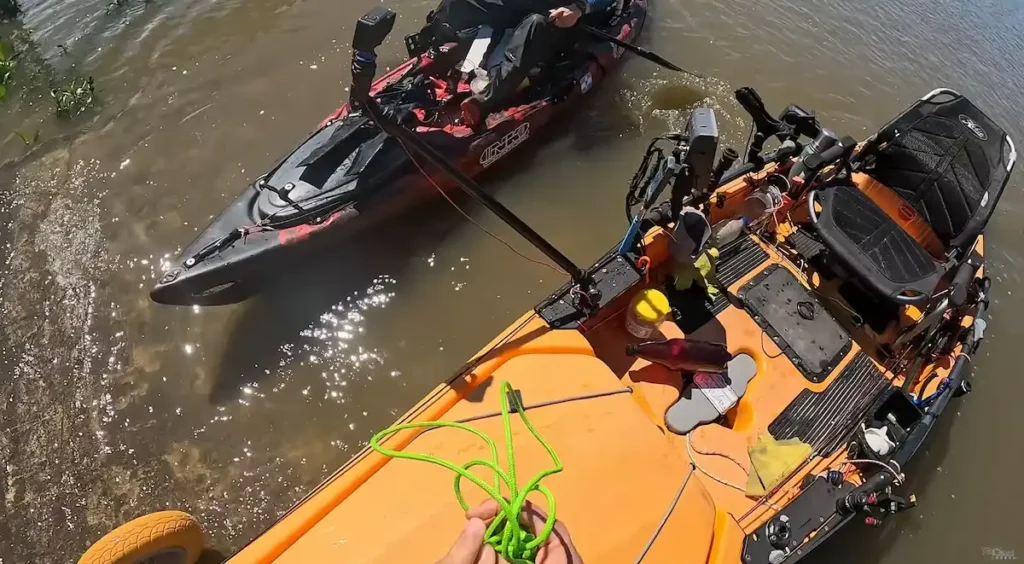 Pescador subiendo el kayak equipado sobre el carrito de transporte por la rampa o costa en el Club de Pesca de Quilmes al finalizar la jornada