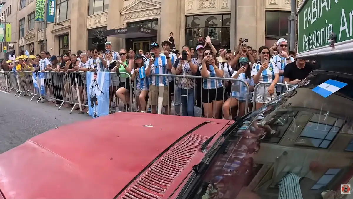 El Rancho Móvil frente al hotel de la Selección en Dallas Una toma al aire libre en pleno centro de Dallas que muestra al icónico vehículo "Rancho Móvil" estacionado cerca del hotel de la Selección Argentina. En el lugar se observa un imponente despliegue con patrulleros y oficiales de la policía local custodiando la zona, rodeados por una multitud de hinchas con camisetas celestes y blancas que esperan la salida de los jugadores.
