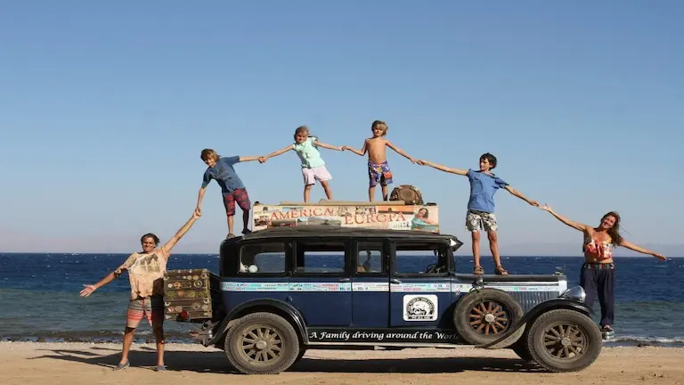 Herman y Candelaria Zapp junto a sus cuatro hijos posando sobre su auto clásico Graham-Paige 1928 frente al mar durante su vuelta al mundo.