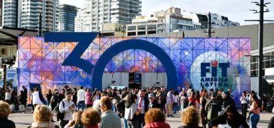 Entrada principal a la Feria Internacional de Turismo (FIT América Latina) con una gran estructura que forma el número 30 y una multitud de asistentes al aire libre.