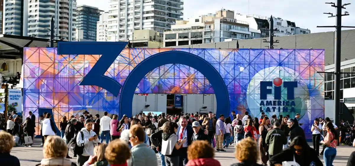 Entrada principal a la Feria Internacional de Turismo (FIT América Latina) con una gran estructura que forma el número 30 y una multitud de asistentes al aire libre.