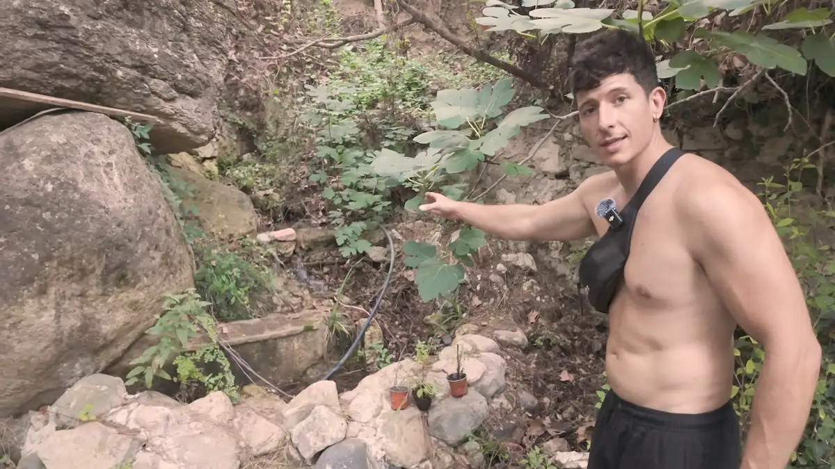 Mark señala la vertiente de agua de montaña que abastece de agua potable a la finca autosuficiente.
