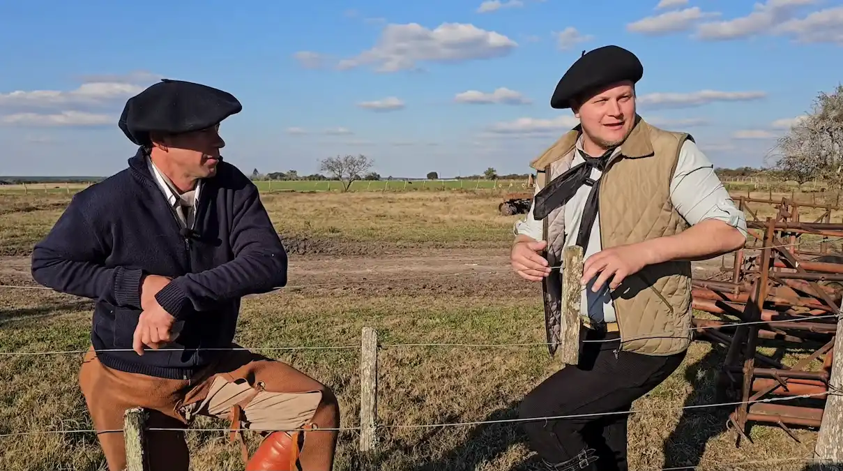 Mauro Besson y Ariel conversando junto a un alambrado durante una entrevista en el campo.
