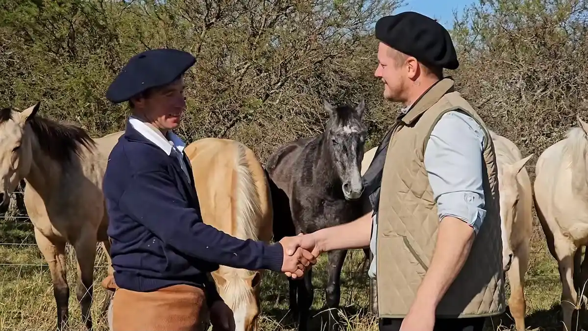 Mauro Besson y el paisano Ariel sellando el encuentro con un apretón de manos frente a los caballos criollos en Entre Ríos.