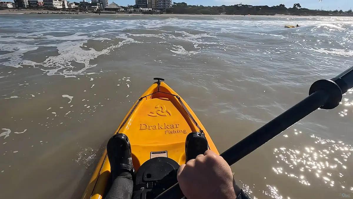 Salida del mar y regreso a la playa tras la jornada de pesca en kayak en Santa Teresita