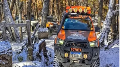 Toyota Hilux de Sin Huellas 4x4 equipada para expedición off-road avanzando entre la nieve y el bosque patagónico hacia el Paso Río Mayer.