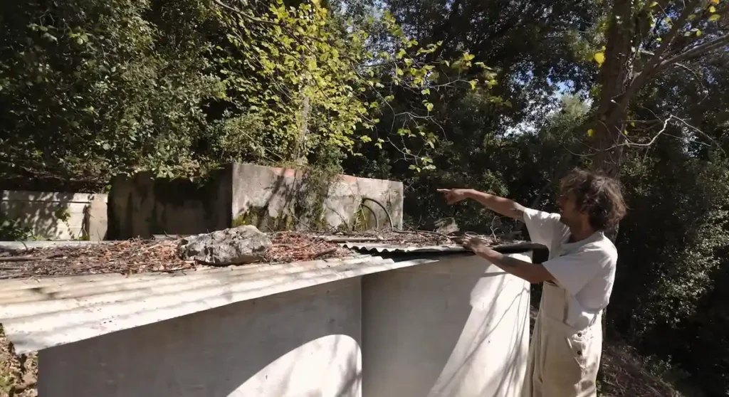 Alex señalando los depósitos de almacenamiento de agua de río para el abastecimiento de la finca Can Dansa
