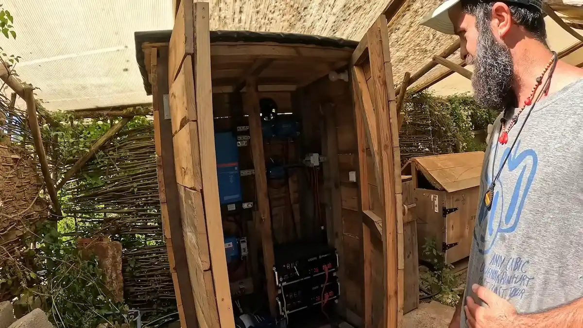 Texto alternativo (Alt Text): Caseta de madera con el sistema fotovoltaico, inversor y baterías de la comunidad
