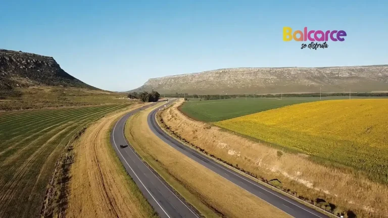 Vista aérea de la Autovía 226 con campos y el cordón serrano de Tandilia en Balcarce con logo institucional.